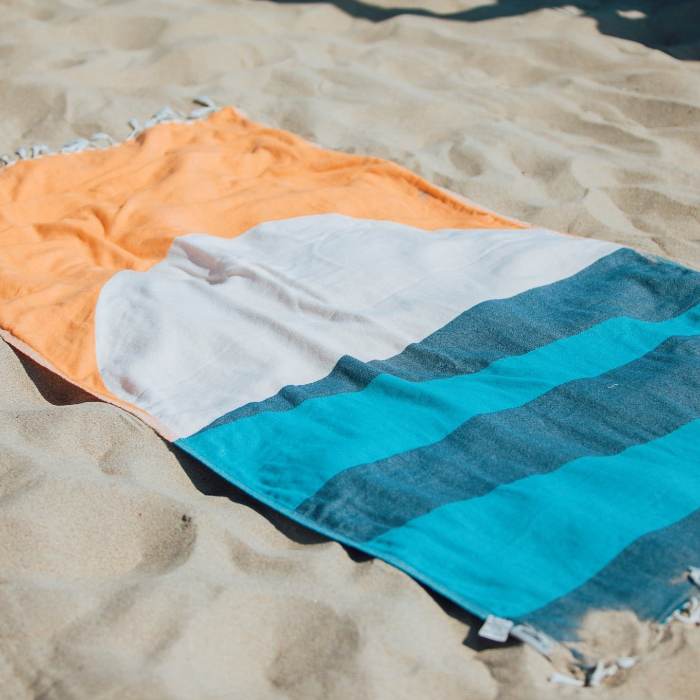 Detail of beach towel in the sand.